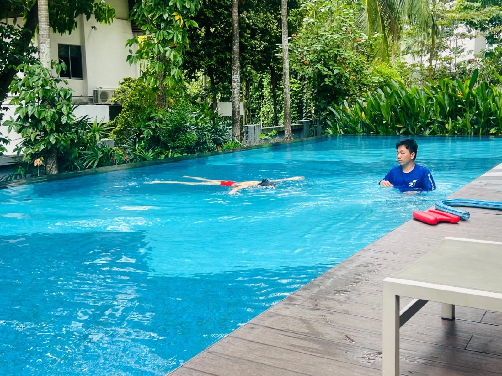 Penguin Swim School coach supervising a learner during adult beginner style swimming practice