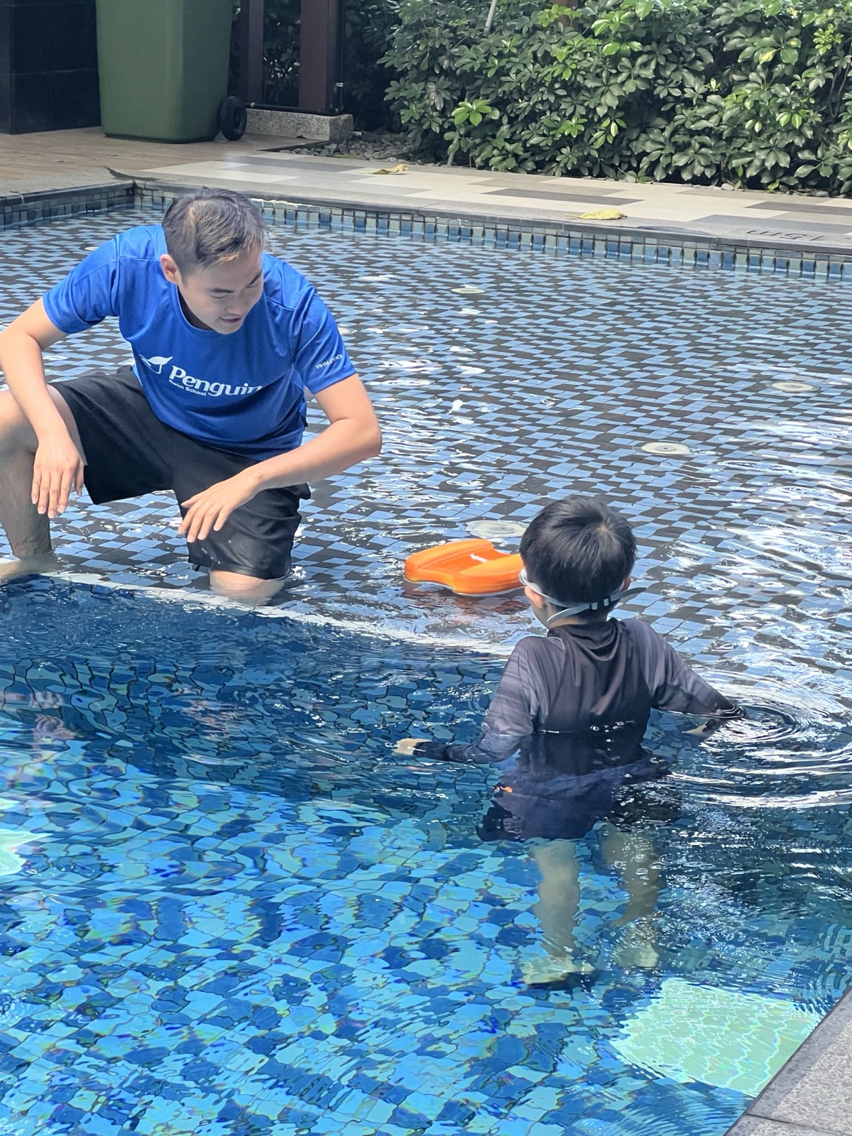 Penguin Swim School coach supervising a child during a private condo pool swimming lesson in Singapore