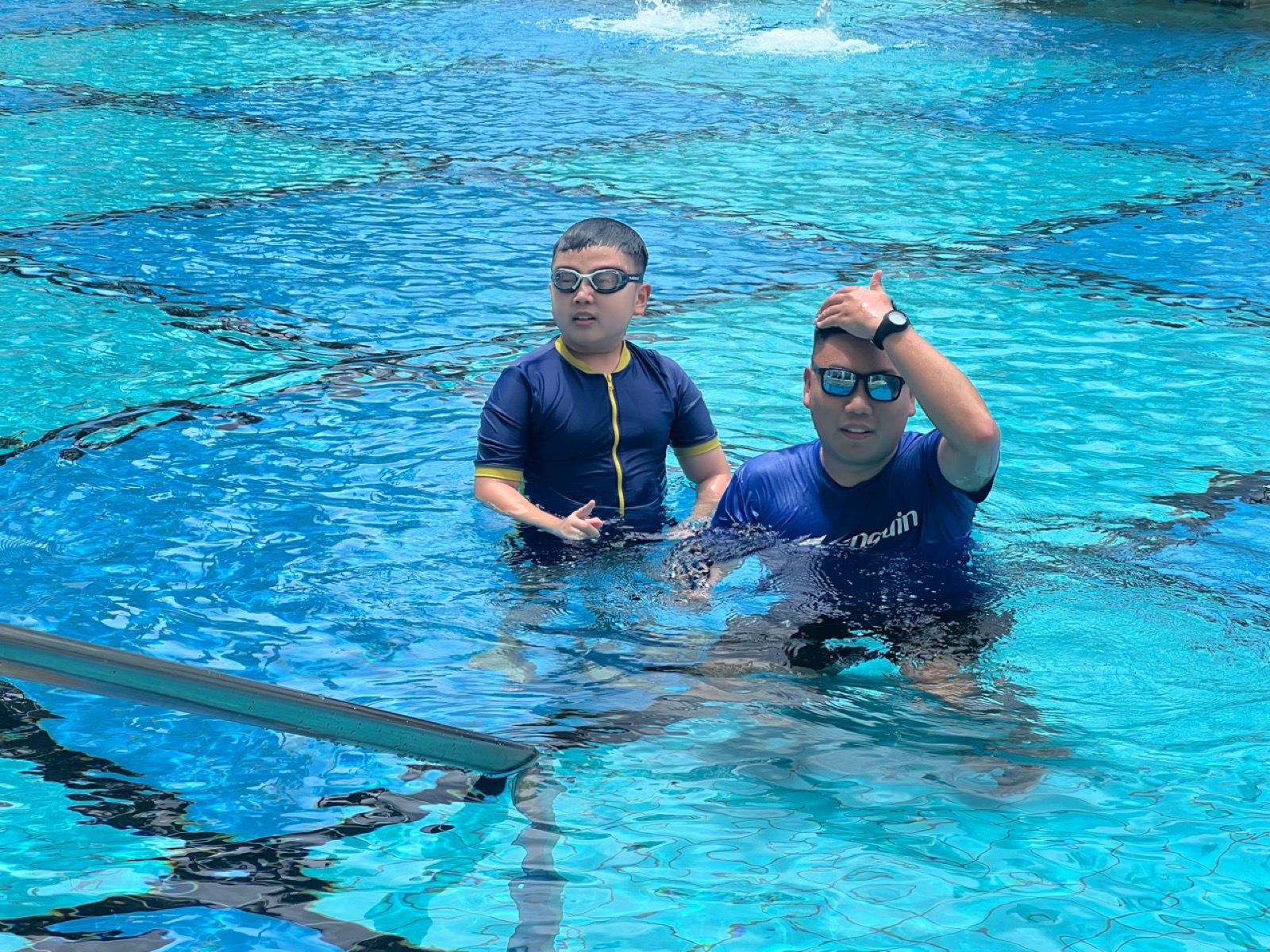 Penguin Swim School coach working closely with a learner in a Singapore swimming pool