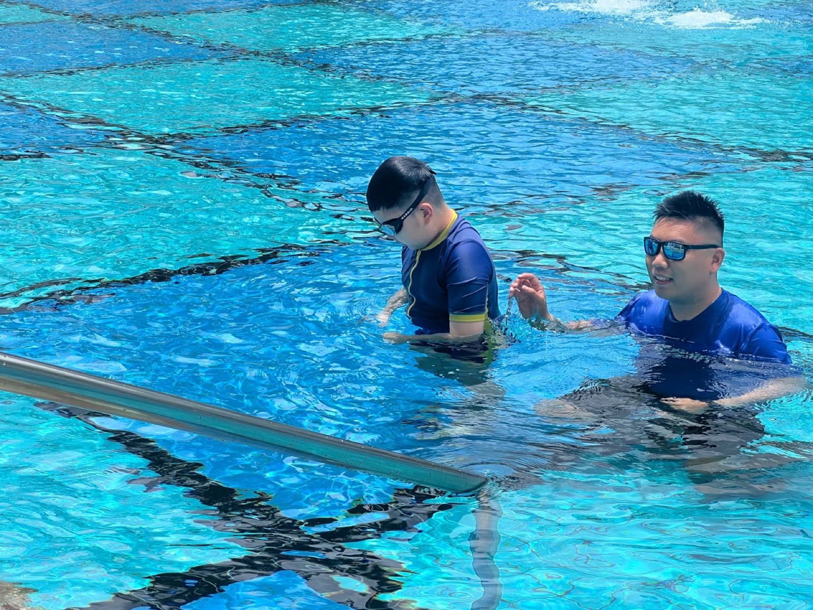 Penguin Swim School private swimming lesson with coach guiding a learner in the pool