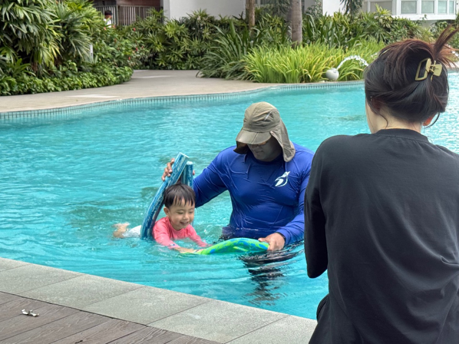 Penguin Swim School coach supporting a young child during early swimming lessons at a Singapore pool