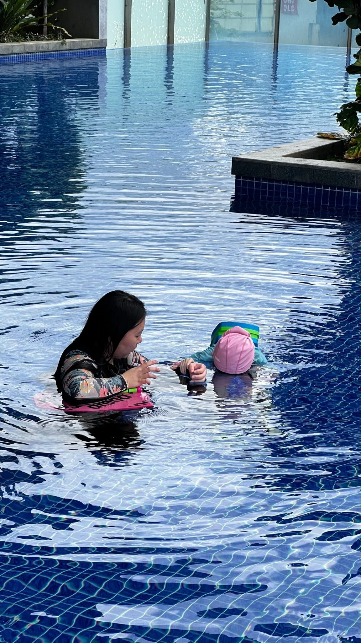 Penguin Swim School female coach guiding a learner during a privacy-conscious Singapore swimming lesson